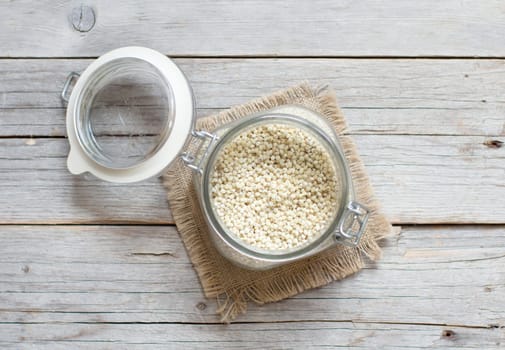 Sorghum grain in a glass jar on wooden background