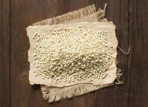 White Sorghum grain on wooden table close up