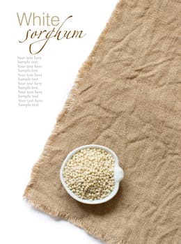 White Sorghum grain in a bowl on burlap background