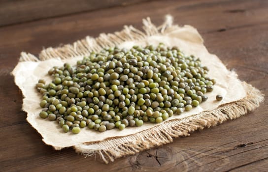 Pile of uncooked Mung beans on a wooden table