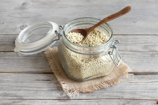White Sorghum grain in a glass jar on wooden table