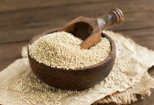 White Quinoa in a bowl with a wooden spoon close up
