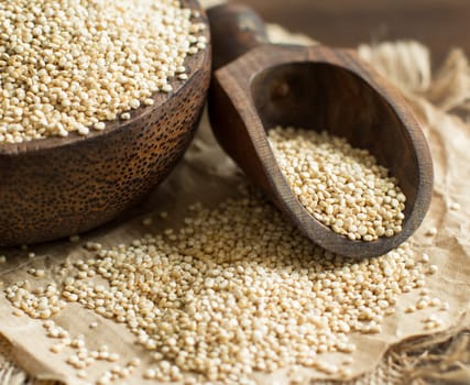 White Quinoa with a wooden spoon and bowl close up