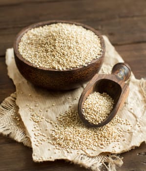 White Quinoa in a bowl with a wooden spoon close up