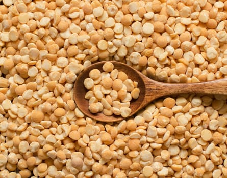 Uncooked Yellow split peas with a spoon close up