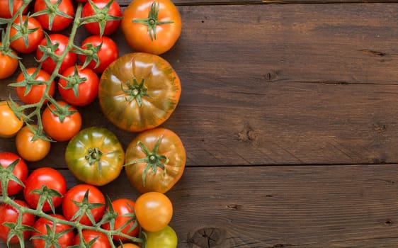 Fresh costoluto and cherry tomatoes on a wooden background