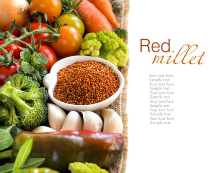 Uncooked brown millet in a bowl with vegetables isolated on white