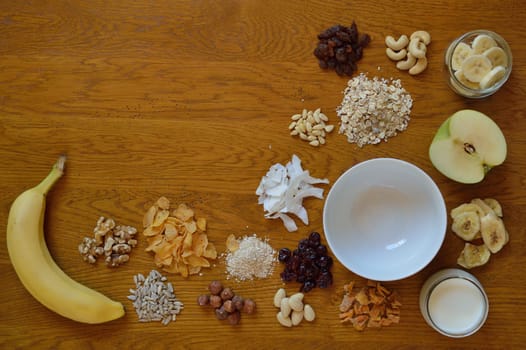 Muesli bowl on breakfast table with individual components of a muesli around it