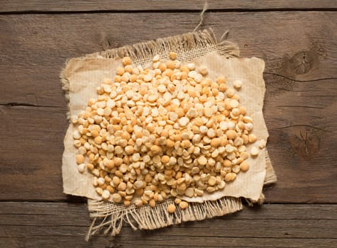 Pile of split yellow peas on wood close up
