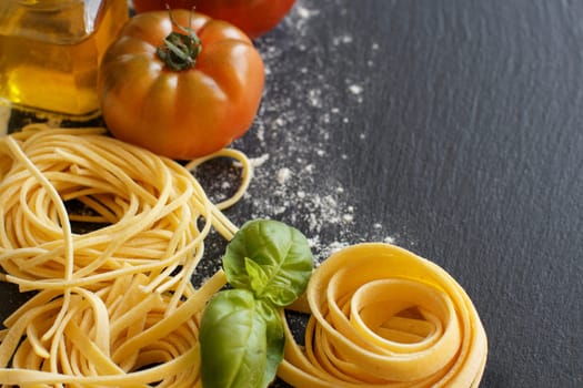 Fresh pasta and ingredients on a dark board
