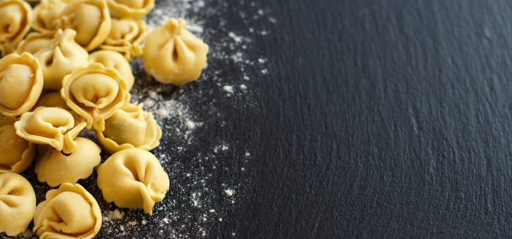 Homemade raw Italian tortellini on a dark background