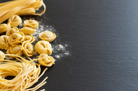 Homemade raw Italian pasta on a dark background