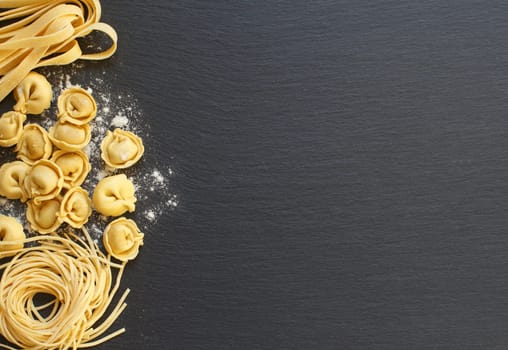 Fresh uncooked italian pasta on a dark background