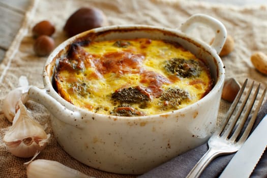 Casserole with broccoli on a rustic background closeup
