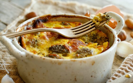 Casserole with broccoli on a rustic background closeup