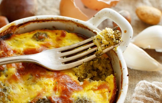 Casserole with broccoli on a rustic background closeup