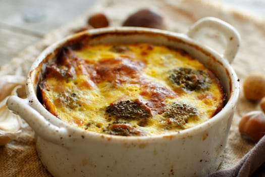 Casserole with broccoli on a rustic background closeup
