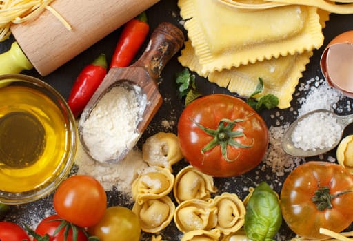 Fresh pasta and ingredients on a dark board