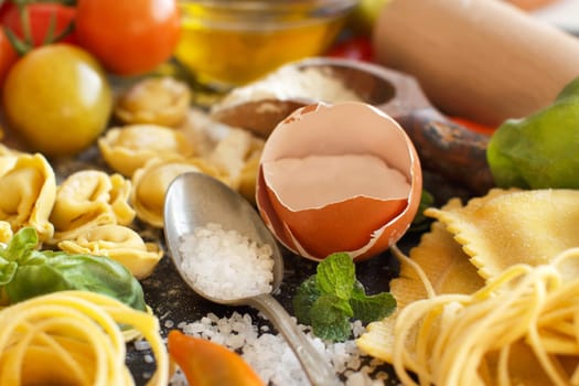 Fresh pasta and ingredients on a dark board