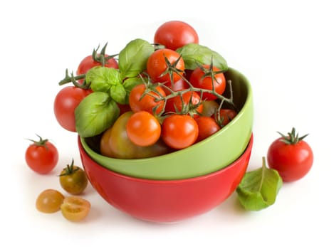 Cherry tomatoes and basil in bowl isolated on white background