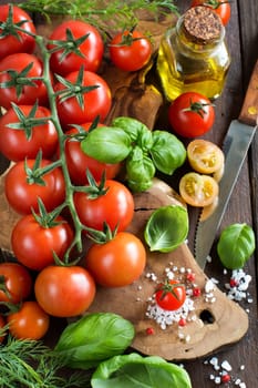 Cherry tomatoes, basil and olive oil on a wooden table