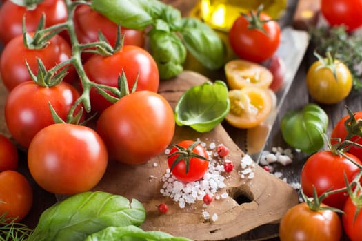Cherry tomatoes, basil and olive oil on a wooden table