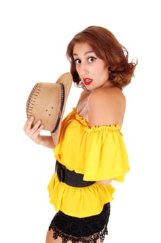 A beautiful woman in a yellow blouse and black shorts looking surprised.into the camera, standing isolated for white background..