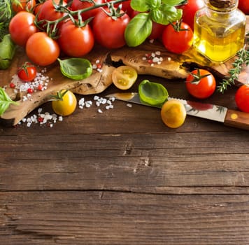 Cherry tomatoes, basil and olive oil on a wooden table