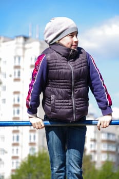 Young athletic girl hanging on horizontal bar