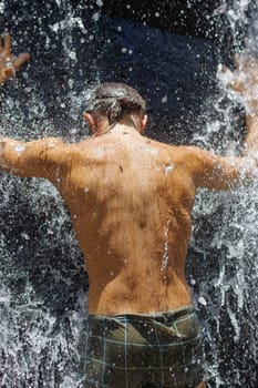 a man taking a relaxing shower under a waterfall outside