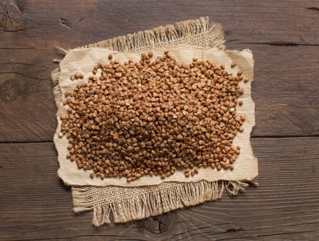 A pile of buckwheat on a wooden table top view