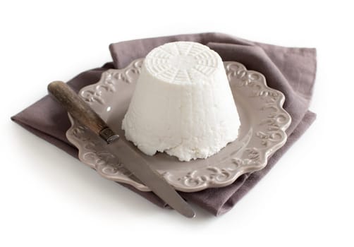 Italian ricotta cheese with knife on napkin isolated on white