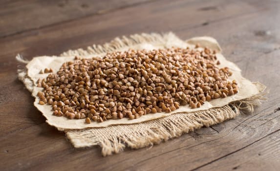 A pile of buckwheat on a wooden table