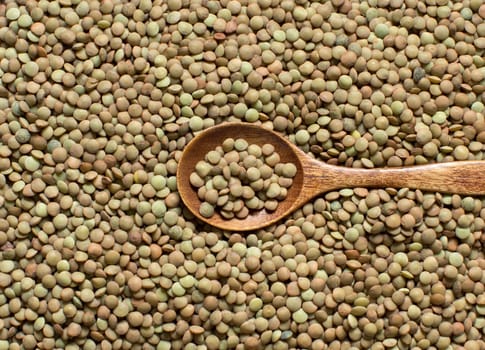 Green lentils with a spoon top view close up