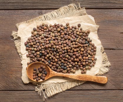 Raw organic roveja beans with a spoon on a wooden table