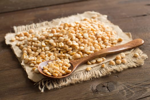 Pile of dried yellow peas with a spoon on a table