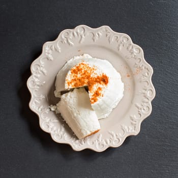 Italian ricotta cheese on a dark background top view