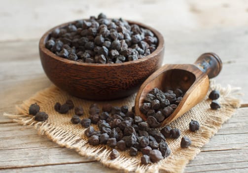 Black Chickpea in a bowl with a spoon on a wooden table