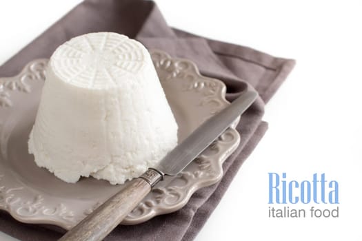 Italian ricotta cheese with knife on napkin isolated on white