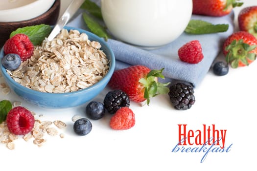 Rolled oats in a bowl with berries and milk isolated on white