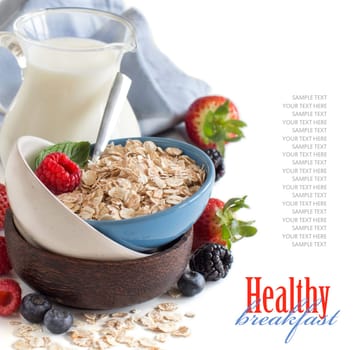 Rolled oats in a bowl with berries and milk isolated on white