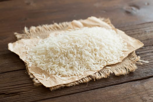 Pile of Basmati rice on a wooden table close up