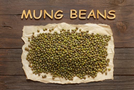 Raw Mung beans with wodden letters top view