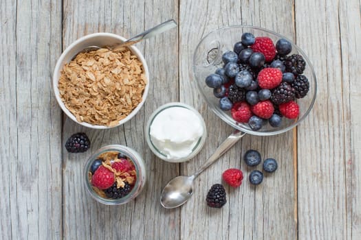 Healthy breakfast with Fresh greek yogurt, flakes and berries on wood