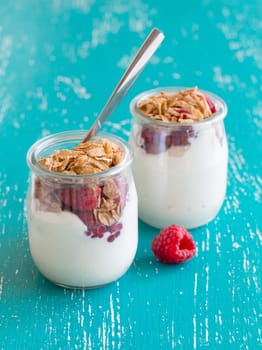 Raspberries, flakes and fresh yogurt in a jar