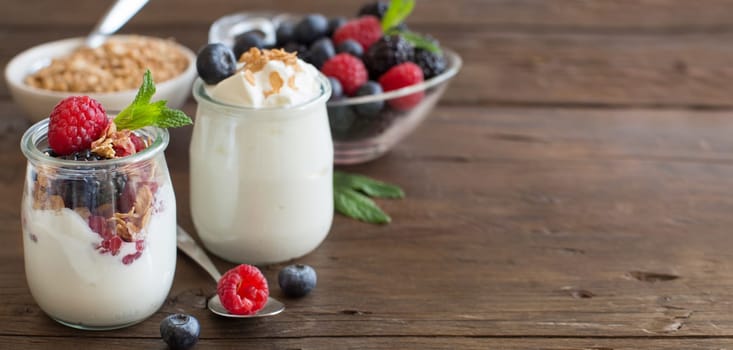 Berries, flakes and fresh greek yogurt on a wooden table