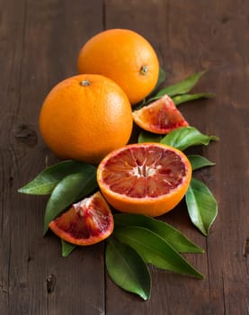 Fresh Sicilian oranges with leaves on a wooden table