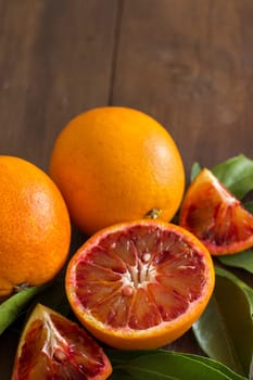 Fresh red Sicilian oranges with leaves on a wooden table
