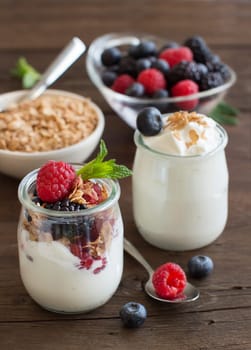 Berries, flakes and fresh greek yogurt on a wooden table