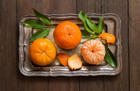 Fresh mandarines on a tray on a wooden table